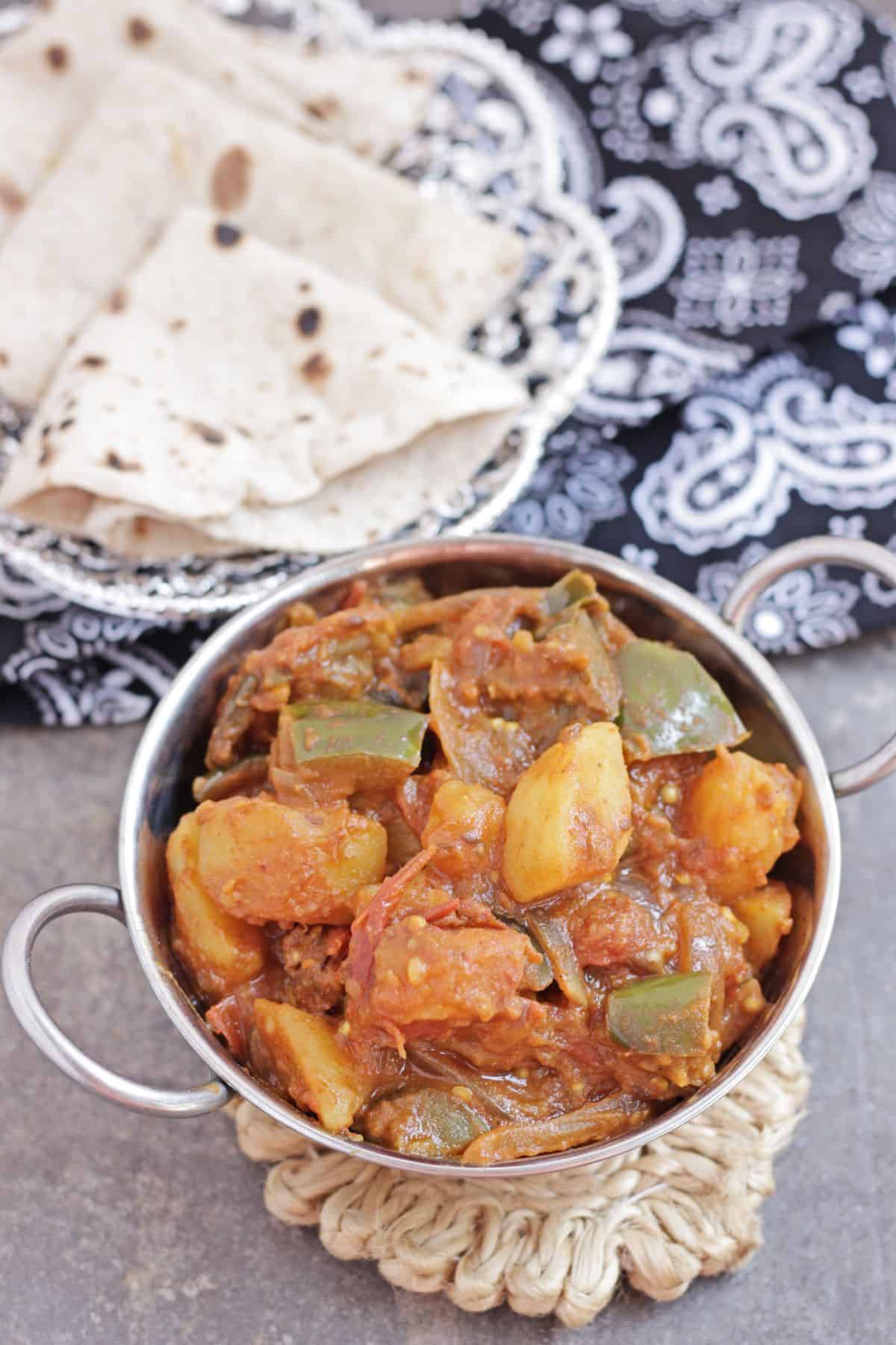 Potato and eggplant curry with roti in the background