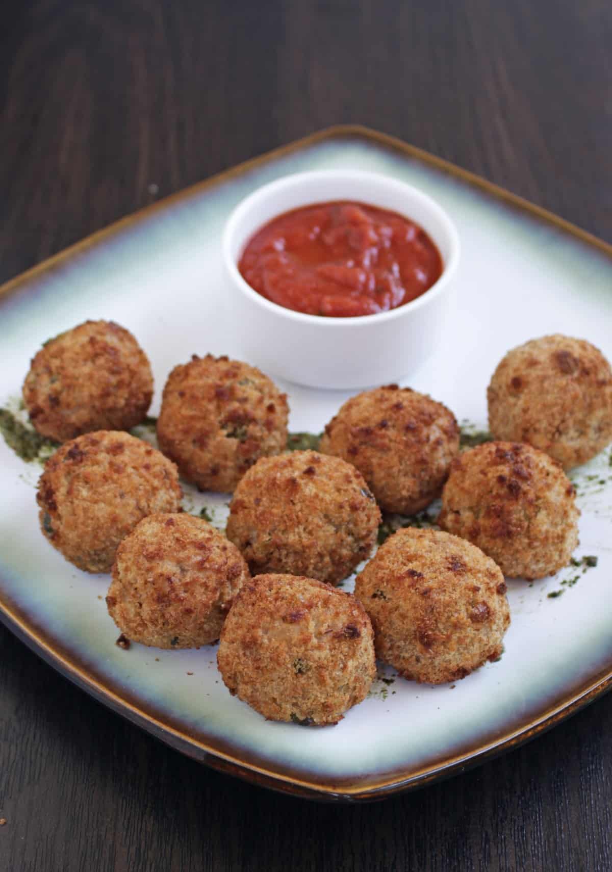 Air fried arancini in a plate served with marinara sauce