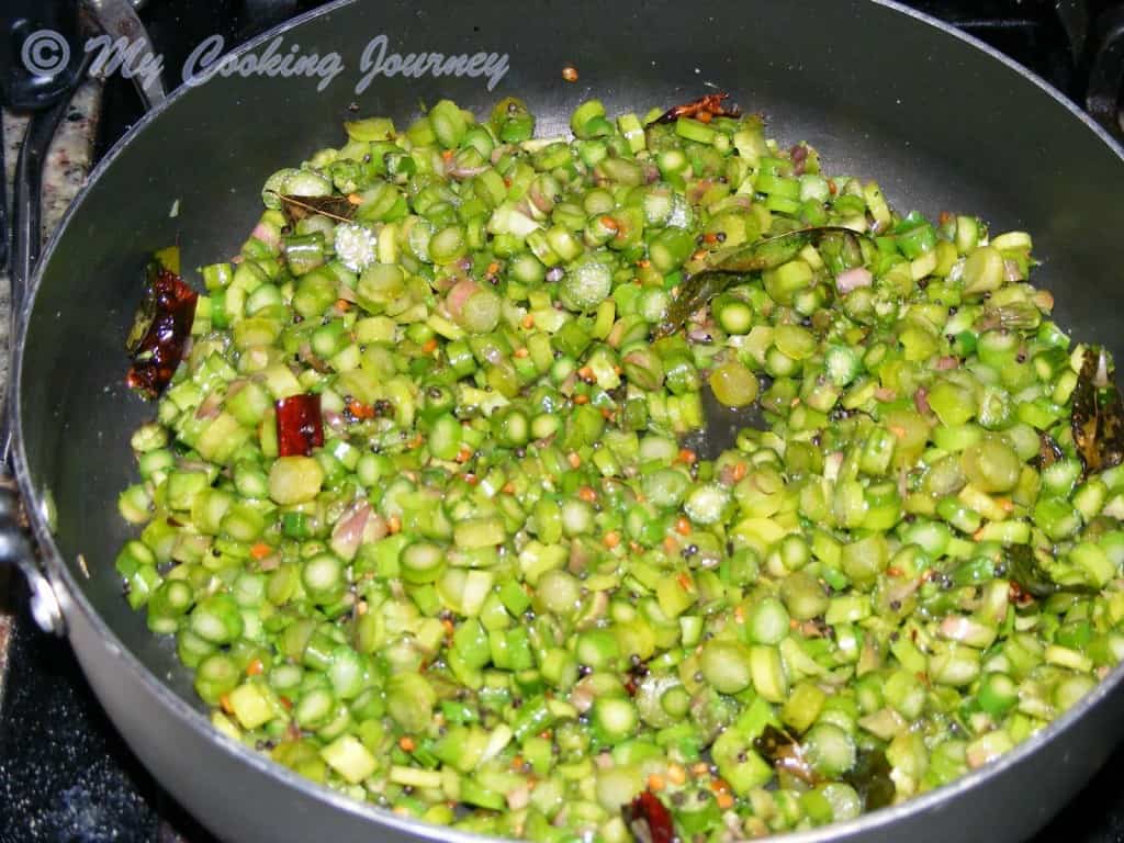 chopped asparagus in pan with seasoning