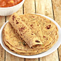 Avocado paratha stacked in a plate with one rolled