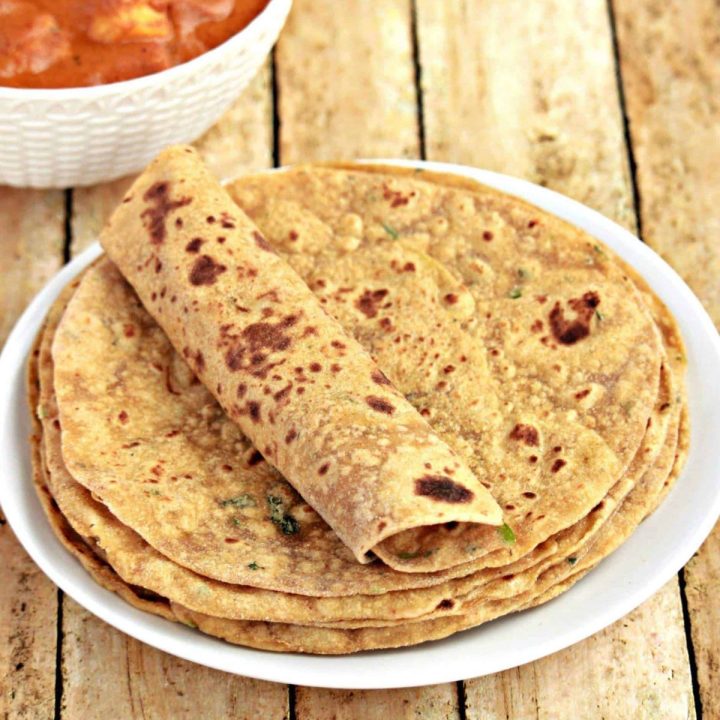 Avocado paratha stacked in a plate with one rolled