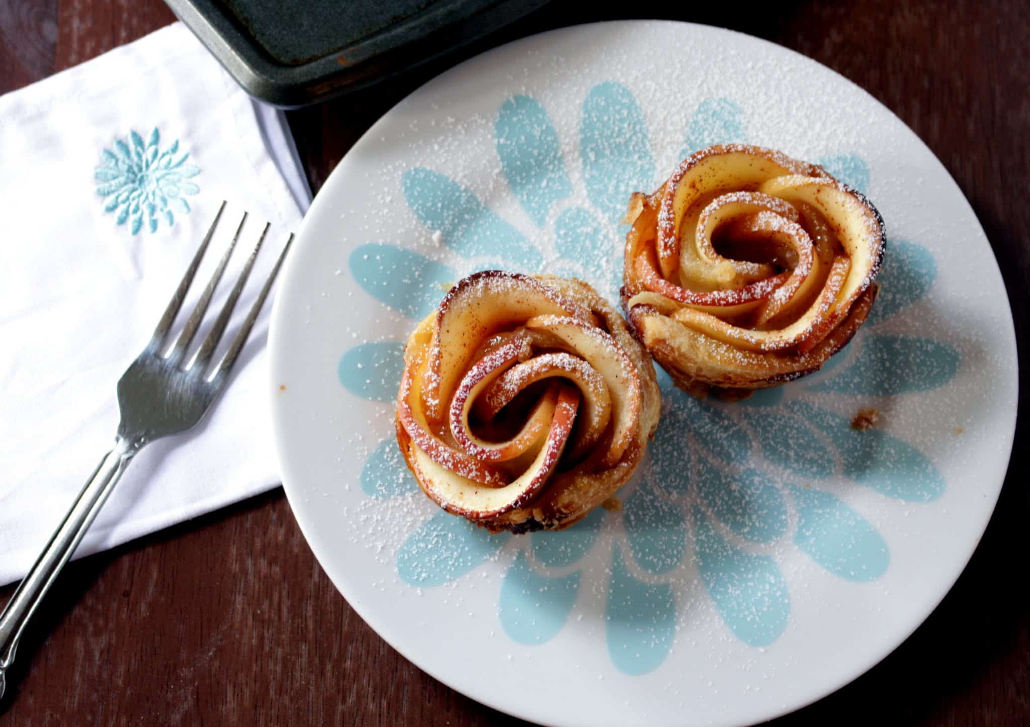 2 apple rose served in blue plate with fork