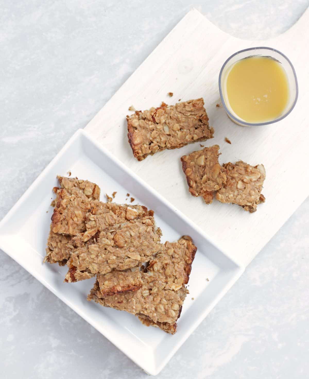 Breakfast bars served in a plate with orange juice in the side. 