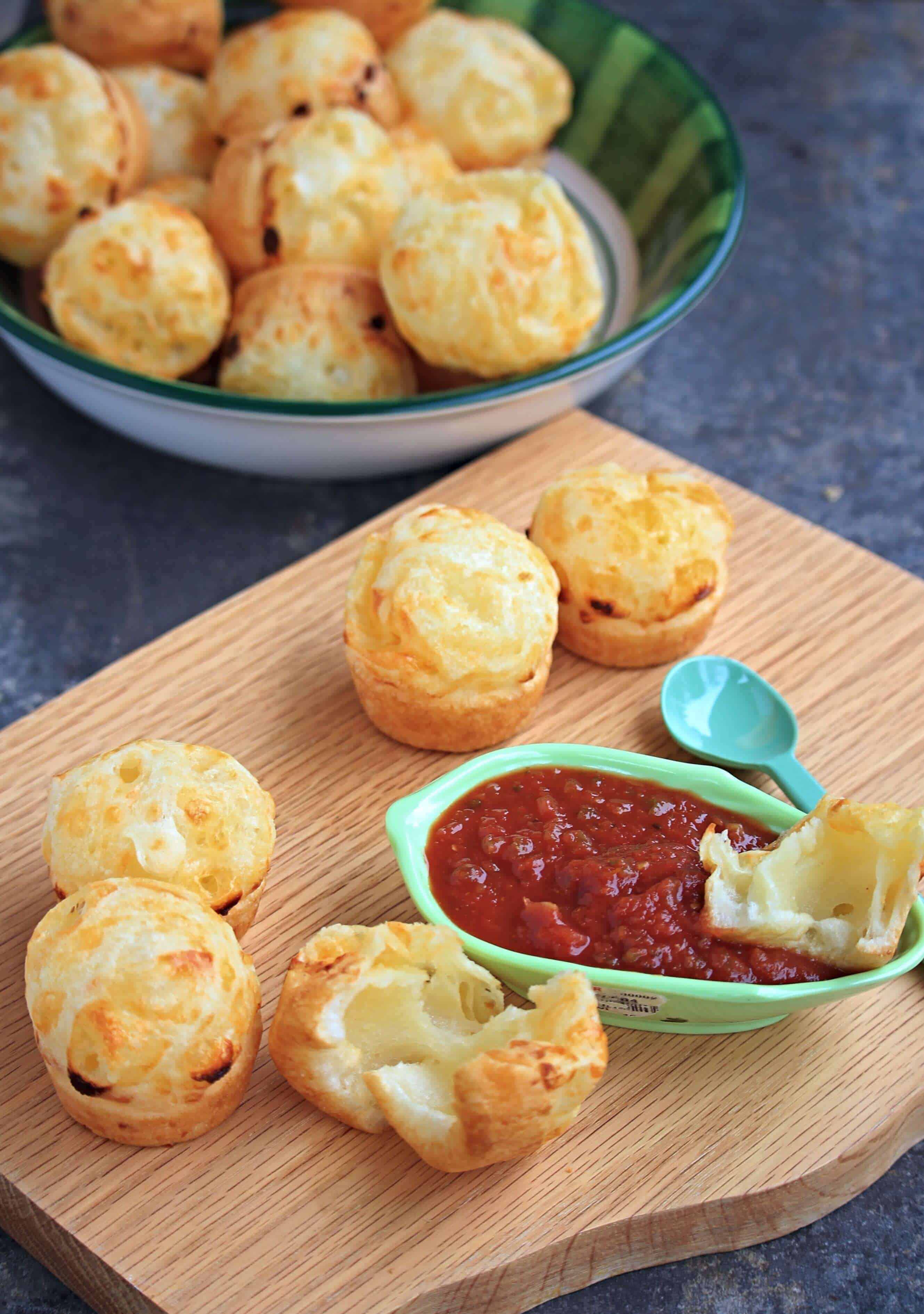 sliced opened Brazilian cheese bread dipped in salsa