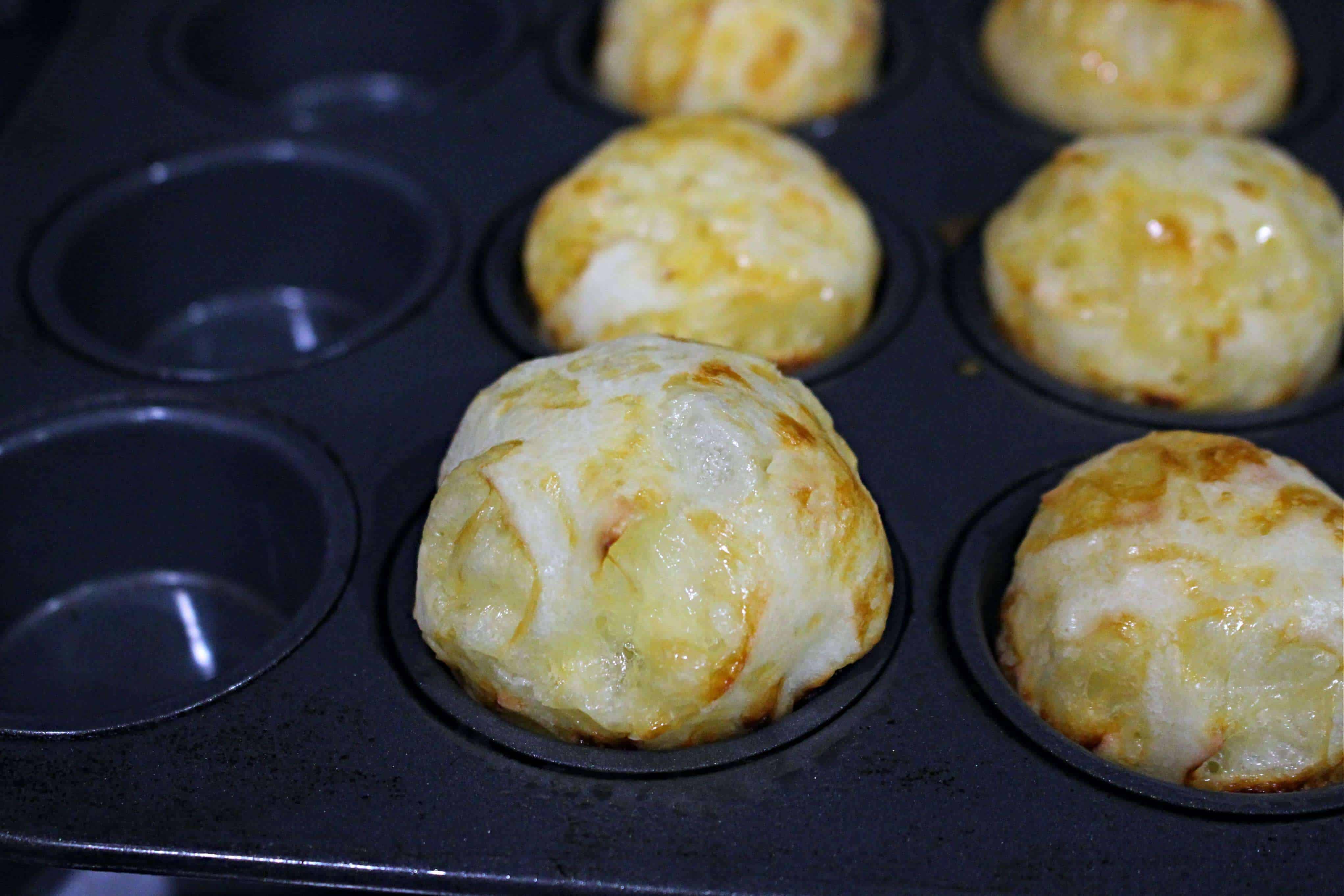 puffed up Brazilian cheese bread in a muffin tin