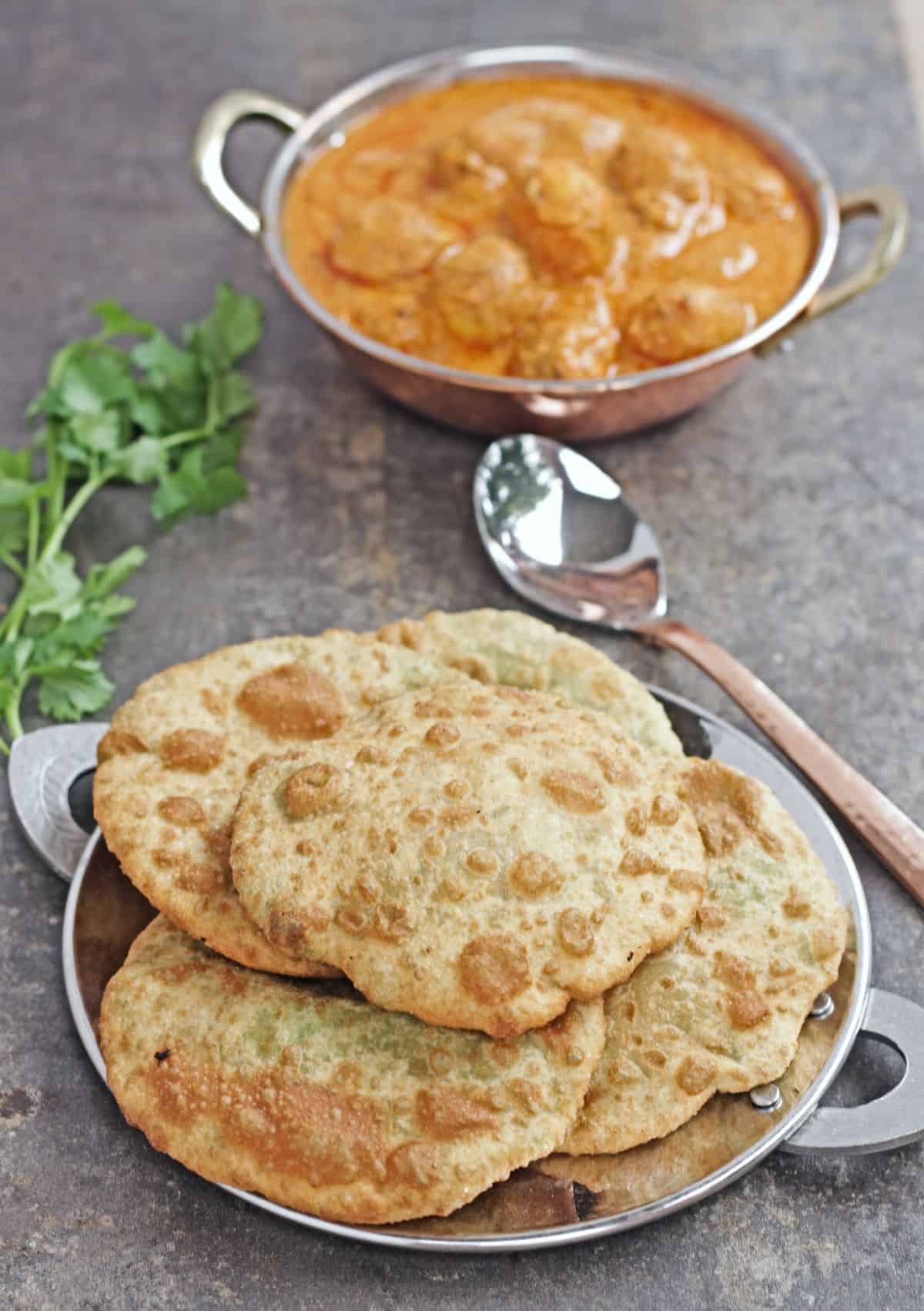 Green peas kachori on a plate with dum aloo on the background