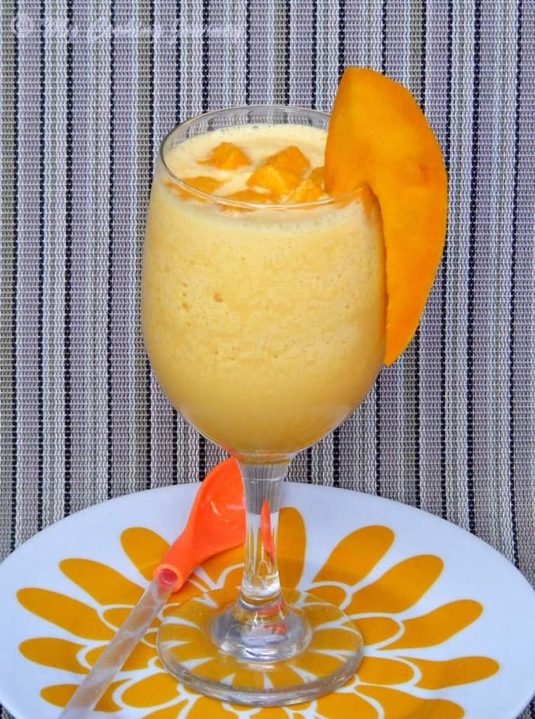 Mango Julius in a serving glass garnished with mango