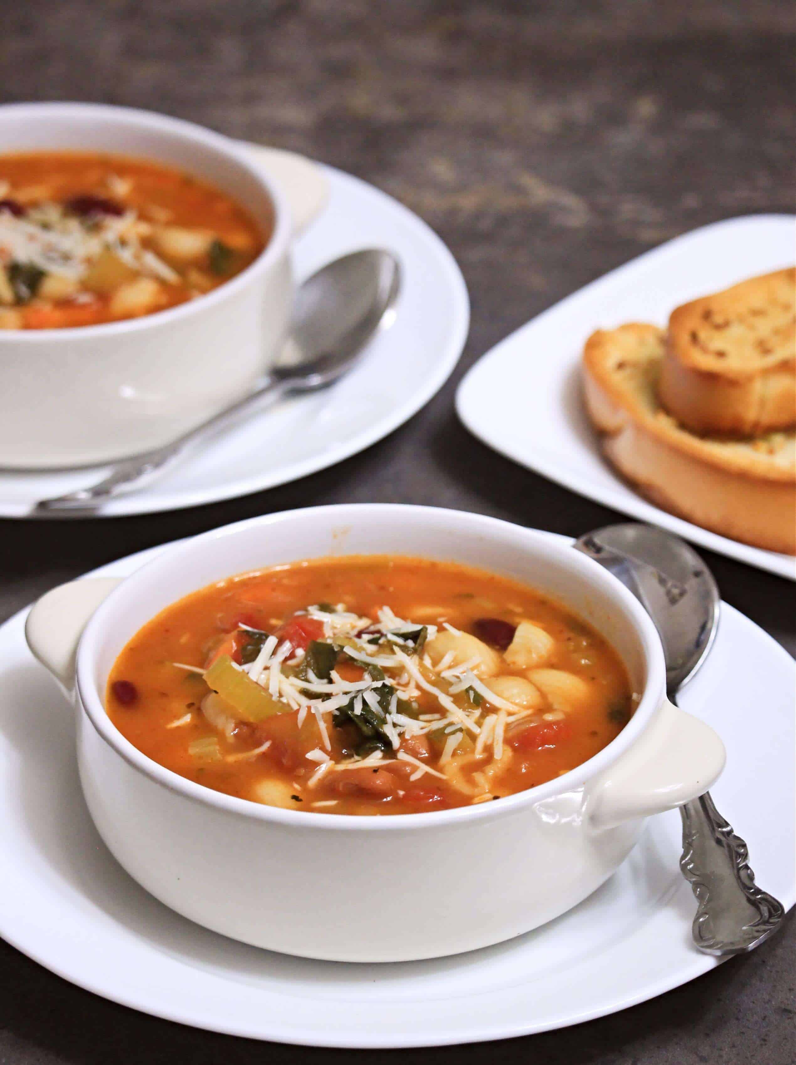 Soup with cheese on top in a white bowl