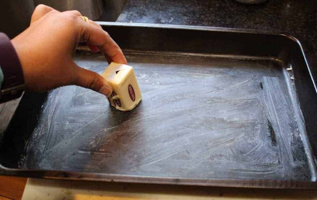 rubbing butter on a tray