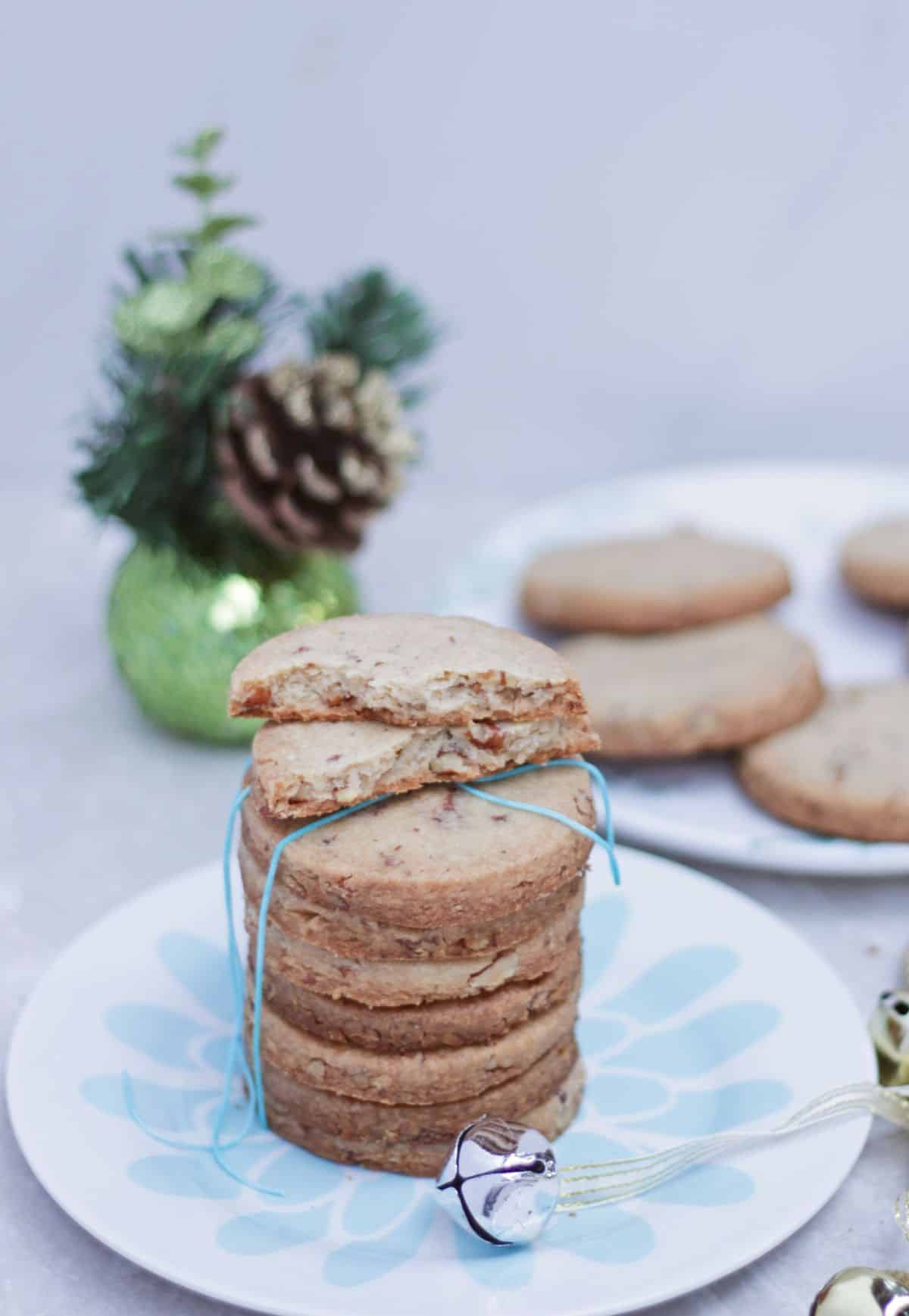 Stacked pecan shortbread cookies with a half broken cookie on top