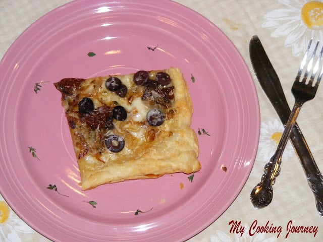 Sun dried tomato and Onion tart served in a plate.