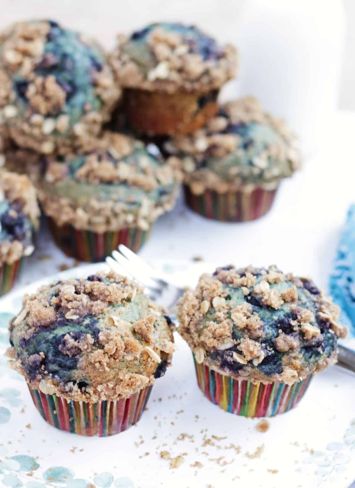 2 vegan banana blueberry crumb muffin in a plate with more in the background